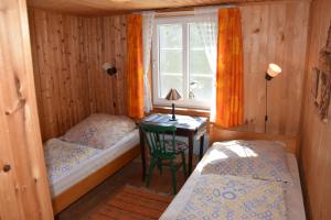 ein Zimmer mit zwei Betten und einem Tisch mit Fenster in der Unterkunft Idyllisches Landhaus mit Ruderboot, Südschweden in Vissefjärda