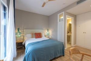 a bedroom with a bed with a blue blanket at Hostal Boutique Es Portalet in Sant Feliu de Guíxols