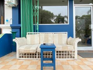 a bench sitting on a porch with a blue table at Awany CoLiving in Jakarta
