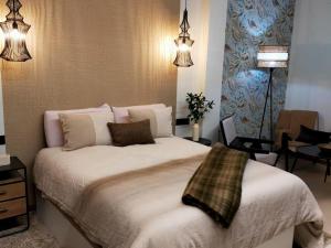 un dormitorio con una cama con sábanas y almohadas blancas en Alojamiento Beach Riazor, en A Coruña