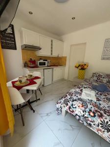 a bedroom with a bed and a table and a kitchen at Marie Studio COSY in Sanary-sur-Mer