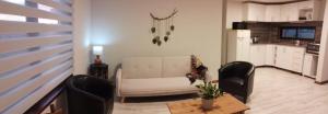 a living room with a white couch and two chairs at La Calandria in Carmelo