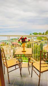 a table with a vase of flowers on a balcony at Palacio in Kaybagal