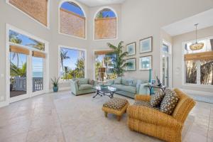 a living room with couches and tables and windows at Captiva Grace home in Captiva +50 photos