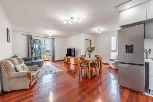 eine Küche und ein Wohnzimmer mit Tisch und Stühlen in der Unterkunft Cozy Seaside Cottage Ocean Views and Near Beach in Caniço