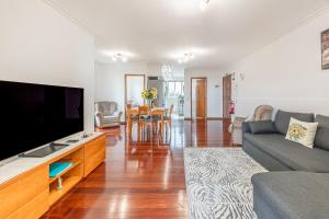 ein Wohnzimmer mit einem großen Flachbildfernseher in der Unterkunft Cozy Seaside Cottage Ocean Views and Near Beach in Caniço