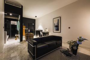 a living room with a black leather couch in it at SU29 Boutique Hotel in Valletta