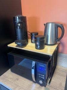 a microwave with two coffee pots on top of it at Le petit Mas in Nîmes