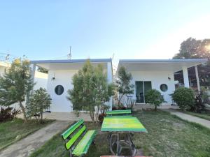 a house with green picnic tables in front of it at Aona Resort Kohlarn in Ko Larn