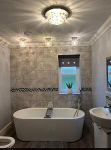 a bathroom with a large tub and a sink at Gellyburn Cottage in Kinross