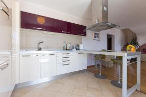 a kitchen with white cabinets and a counter top at Apartman Sara s predivnim pogledom na more in Matulji