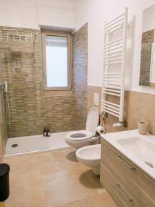 a bathroom with a toilet and a tub and a sink at Violahouse in Bari