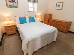 - une chambre avec un grand lit blanc et 2 tables de chevet dans l'établissement Pencroft Cottage, à Leyburn