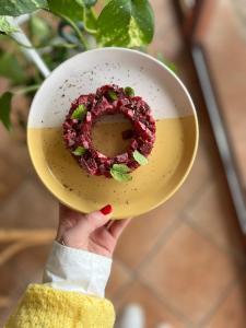 a hand holding a bowl with a donut on it at Golf Hotel de la Carte in Chouzy-sur-Cisse