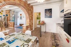 a kitchen and living room with a brick wall at Appartamento Brussa Beach in Castello di Brussa