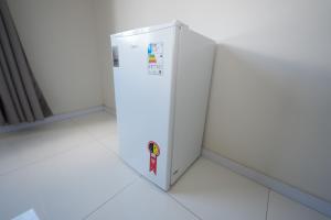 un réfrigérateur blanc est posé dans une pièce dans l'établissement Hotel Pedra Moura, à Vacaria
