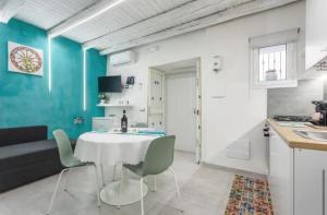 a kitchen and dining room with a white table and chairs at Apartment al Vicolo 27 in Palermo +6 photos