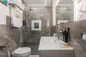 a bathroom with a sink and a toilet and a shower at Apartment al Vicolo 27 in Palermo