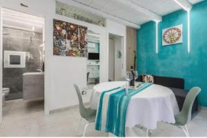 a dining room with a white table and blue walls at Apartment al Vicolo 27 in Palermo