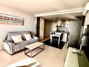 ein Wohnzimmer mit Sofa und Tisch in der Unterkunft Apartaments Voramar in Cambrils