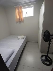 a small white room with a bed and a fan at Pousada Forquilhinha Vista-Mar in Arroio do Silva +15 photos