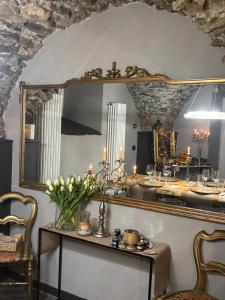 a mirror on a wall with a table with flowers at DANTES in Pieve di Teco +39 photos