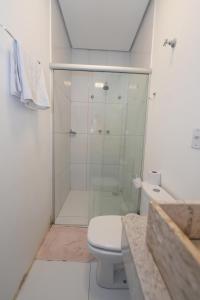 une salle de bain blanche avec douche et toilettes dans l'établissement Hotel Pedra Moura, à Vacaria