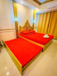 a bedroom with a large bed with red sheets and red pillows at Palacio in Kaybagal