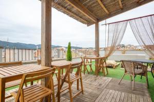 a balcony with wooden tables and chairs and a view at Hostal Boutique Es Portalet in Sant Feliu de Guíxols