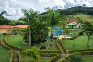 an aerial view of a resort with a pool and palm trees at Hotel Fazenda Monte Sião in Monte Sião