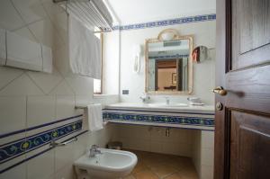 a bathroom with a sink and a toilet and a mirror at Hotel Ristorante le Gole di Ricci in Aielli +14 photos