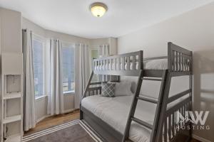 a bedroom with two bunk beds and two windows at Charming Home ear Triple Play Silverwood Hayden Lake Fire Pi Fenced Yard a Plum Tree 1219 in Hayden