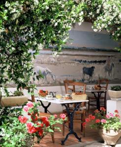 una mesa y sillas en una habitación con flores en Hôtel Le Mirage, en Saintes-Maries-de-la-Mer