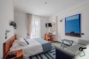 a bedroom with a bed and a chair at Hotiday Porto Venere Le Grazie in Portovenere