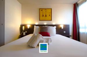 Una habitación de hotel con una cama con toallas. en Best Western l'Atelier 117, en Maubeuge