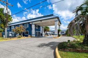 un grande edificio blu con un garage di Americas Best Value Inn-Gonzales a Gonzales