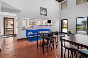 un soggiorno con 2 tavoli e sedie di Americas Best Value Inn-Gonzales a Gonzales