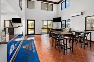 una sala da pranzo con tavoli, sedie e finestre di Americas Best Value Inn-Gonzales a Gonzales