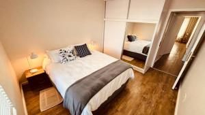 a small bedroom with a bed and a mirror at Nautilus 2 bedroom self-catering apartment in Swakopmund