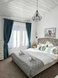 a bedroom with a large bed with blue curtains at EPIC HOUSE Valea Avrigului in Avrig +66 photos