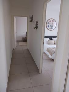 a hallway leading to a bedroom with a bed at L'Eden des Aspres Villa plain pied T4 avec Jardin, terrasse & BBQ in Thuir