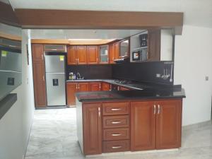 a kitchen with wooden cabinets and a white refrigerator at El Manantial de Sopo in Sopó