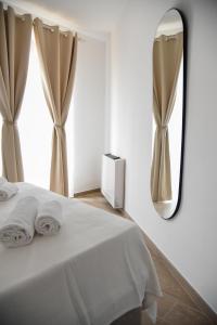 a bedroom with a bed with a mirror and a window at Dimora Maseva - DIEMME STAY in Alberobello +29 photos