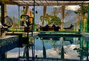 a swimming pool with a couch and a chair next to it at MayaTels - Maya Baas, Rumtek in Gangtok