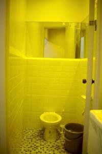 a yellow bathroom with a toilet and a mirror at Meta Rose Mactan Residences in Buaya +1 photo