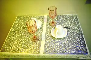 a table with two wine glasses and a plate on it at Meta Rose Mactan Residences in Buaya
