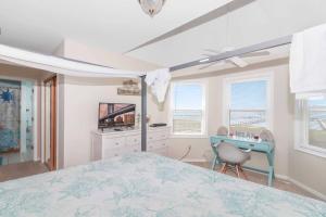 a bedroom with a bed and a desk and windows at Saltwater - Pet friendly, Waterfront! in Black Point Landing