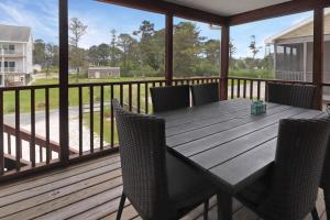 a wooden deck with a table and chairs on it at Saltwater - Pet friendly, Waterfront! in Black Point Landing