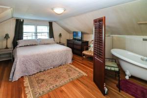 una camera con letto, vasca e TV di Sea Charm - Downtown, Screened porch! a Chincoteague