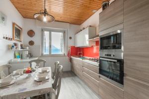 a kitchen with a table and a dining room at Casa HELI 1 in San Zeno di Montagna